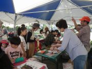 子どもたちに材料の説明をする公園ボランティアさん