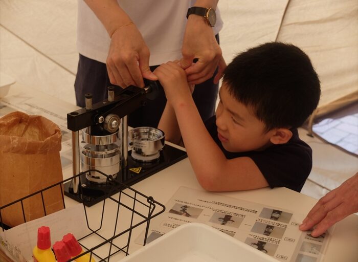 缶バッジマシーンを押しているところ