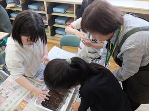 種まきを教えているサポーター