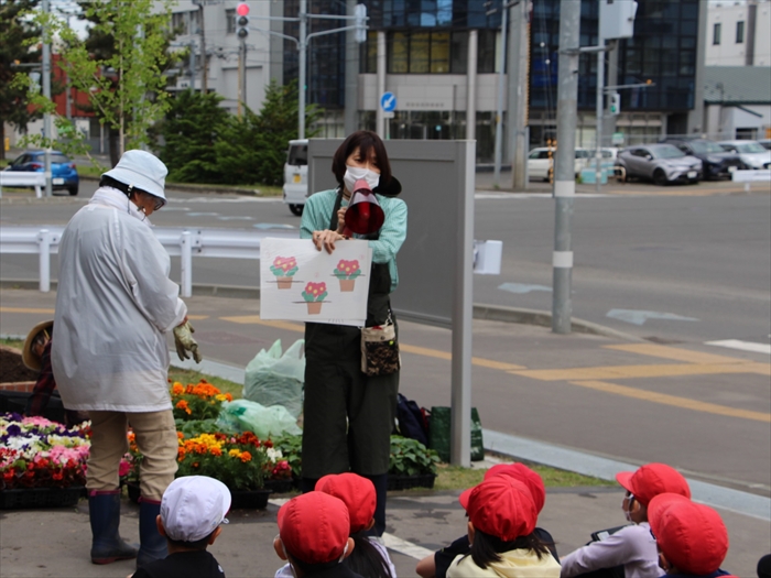 苗の植え方の説明をしている