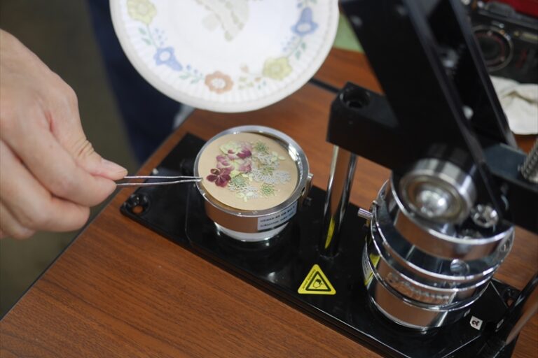 缶バッジマシーンで缶バッジを作っている