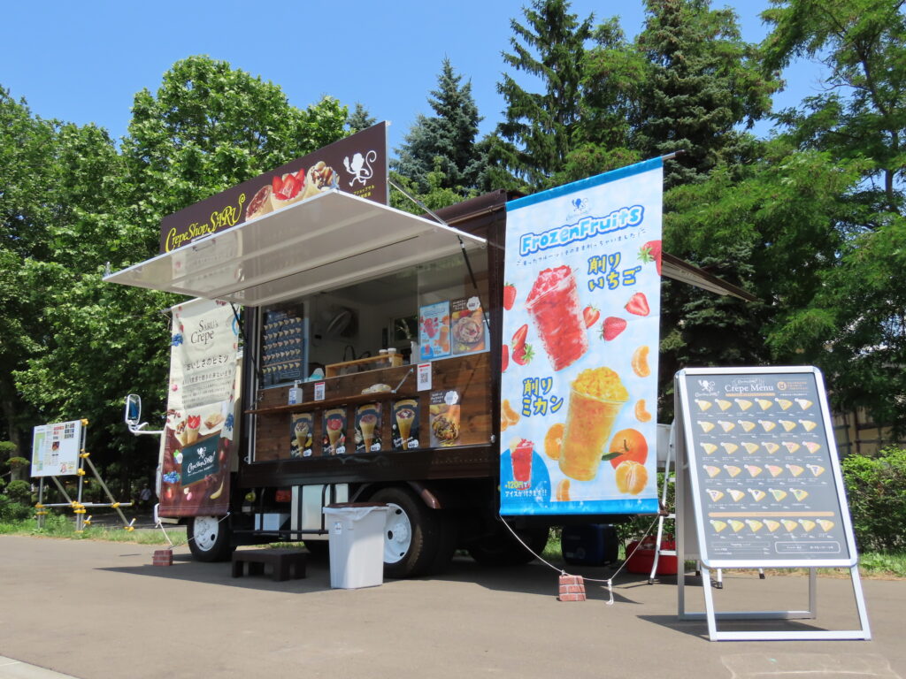 キッチンカーの写真。クレープショップサルさんのキッチンカーは茶色を基調としたおしゃれなキッチンカーです。