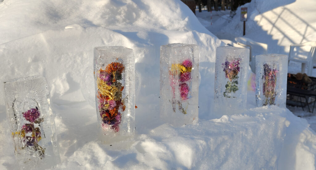 縦長の氷柱の中に花をたくさん詰めた写真