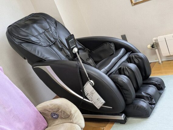 新型マッサージチェア。黒く最新型。脚のマッサージ機能付き。
