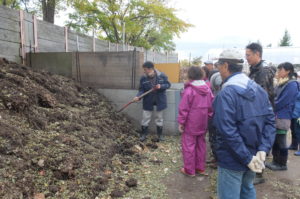 草堆肥の状態を見ている様子