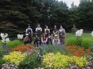 受講生が植栽した花壇の前で記念撮影(都合により加工しています） 