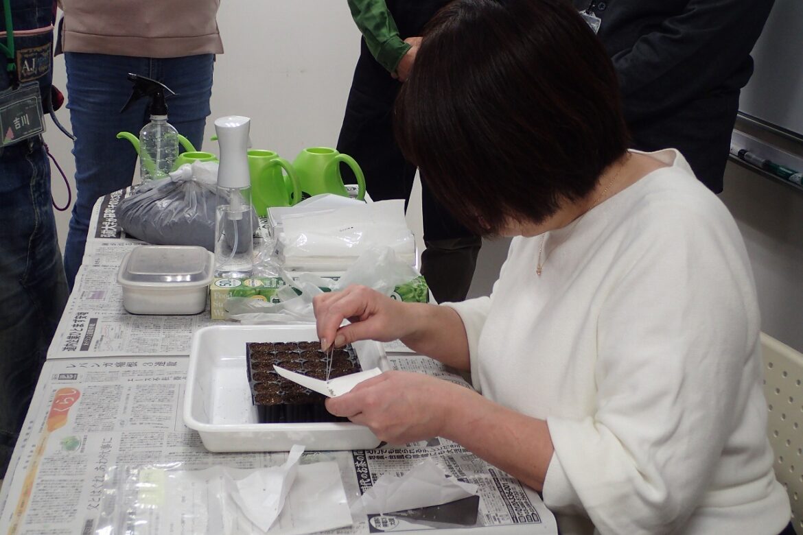 受講者の前で種のまき方を実演する講師