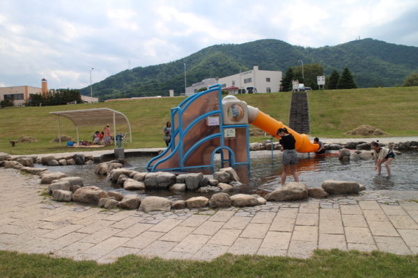 ウォーターガーデン中央に設置された滑り台と遊ぶ子供達