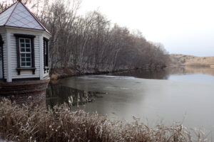 薄っすら雪が積もった取水塔とふちが凍り始めた池