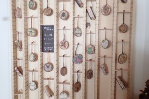 植物や虫、シマエナガが描かれた木の輪切りのストラップ