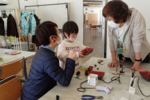 材料を選んできてアドバイスを貰う親子