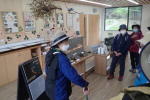 管理事務所でカワセミの話をするボランティアさん