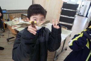 作品と一緒にピースするお子さん