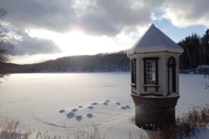 雪の積もった取水塔と池