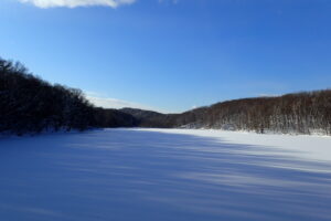氷と雪に覆われた池と青い空