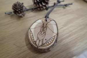 樹の輪切りにバーニングで絵を付けたストラップ