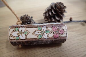 樹の輪切りにバーニングで絵を付けたストラップ