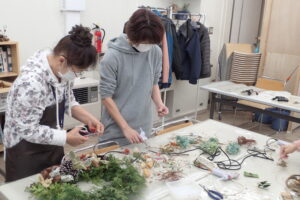 クリスマスリースを作っているボランティアさん