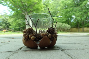 ガラスコップの周りに木の実を付けたもの