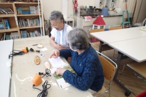 図鑑を見ながら下書きをする参加者