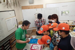 標本の作り方を教えてもらう団員達