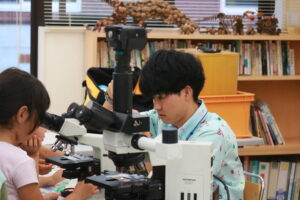 顕微鏡でうろこを見せてくれている