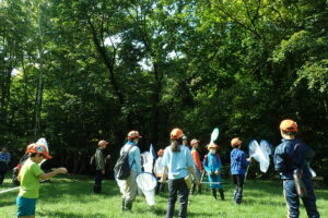広場でトンボの採集をする団員