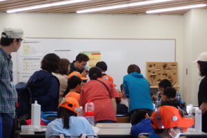 標本作りを見学する団員とスタッフ