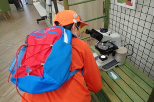 顕微鏡をのぞく団員