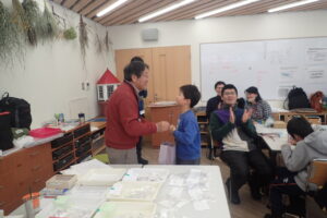 トンボの先生から上手にできた標本の賞を貰う子どもたち