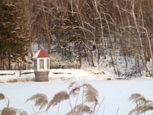 夕日に照らされて雪の中に立つ取水塔
