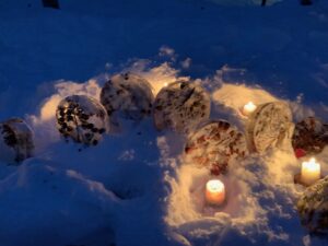 氷のなかにマツボックリを閉じ込めたオブジェがキャンドルに照らされた様子