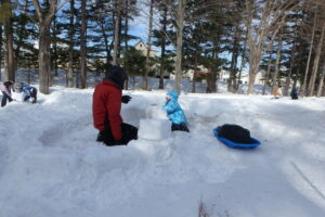 親子でイグルーを作る様子