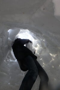 雪のブロックを内側からてっぺんの方に積むお父さん