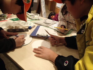 飾りつけのためにイラストを描く子どもたち