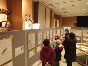 お客さんにポスターの解説をする子ども