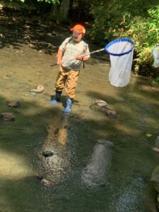 川の中で網を振る子ども