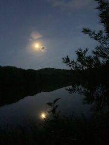 夜の池に月が映る様子