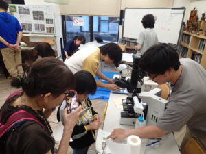 顕微鏡をのぞく子どもたち