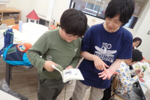 トンボの図鑑を見て同定をする団員