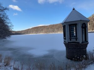 凍った池と赤い屋根の取水塔