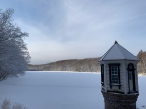 雪をかぶった取水塔と池