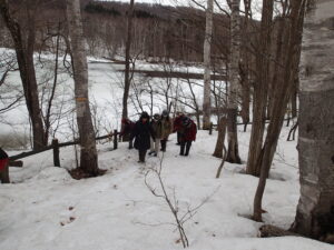 雪の残る園路を歩く参加者