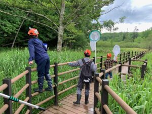 木道で網を振る子供たち