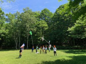 広場でトンボを網に入れようとしている子供たち