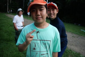 採集したトンボを持つ団員