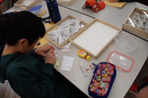標本の裏に厚紙を貼る作業をする子ども