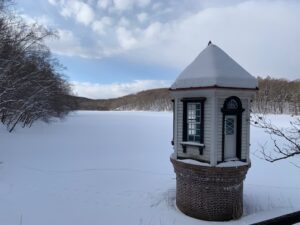 雪の積もった池と取水塔