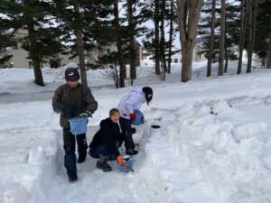 スノーキャンドルの外側の雪灯籠を作る子どもたち