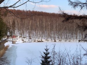 雪の積もった水源池と赤い屋根の取水塔